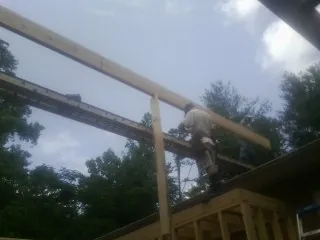 Carpenter setting a ridge beam over a new addition frame — Ice Dam Removal by Roofing Brothers in Lowry